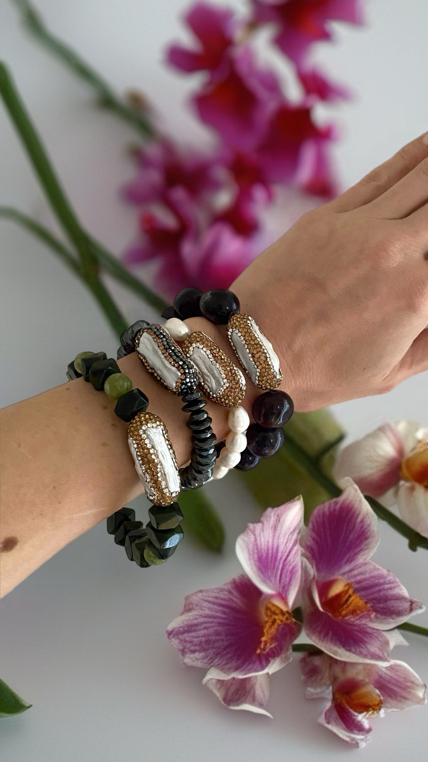 Edles schwarzes Perlenarmband mit glänzenden Kristallen und goldfarbenem Verschluss.