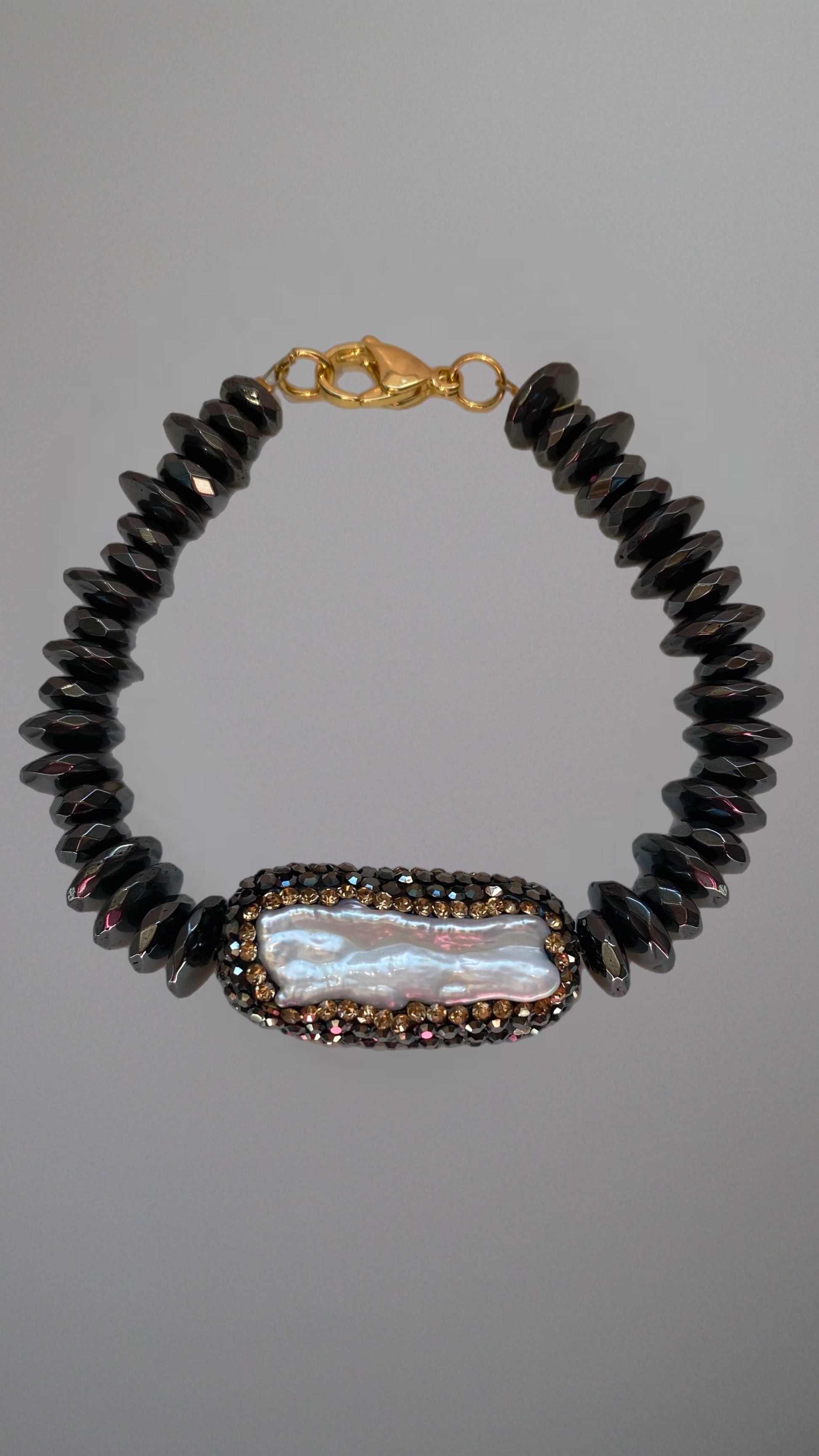 Edles schwarzes Perlenarmband mit glänzenden Kristallen und goldfarbenem Verschluss.