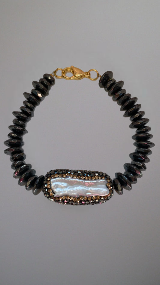 Edles schwarzes Perlenarmband mit glänzenden Kristallen und goldfarbenem Verschluss.